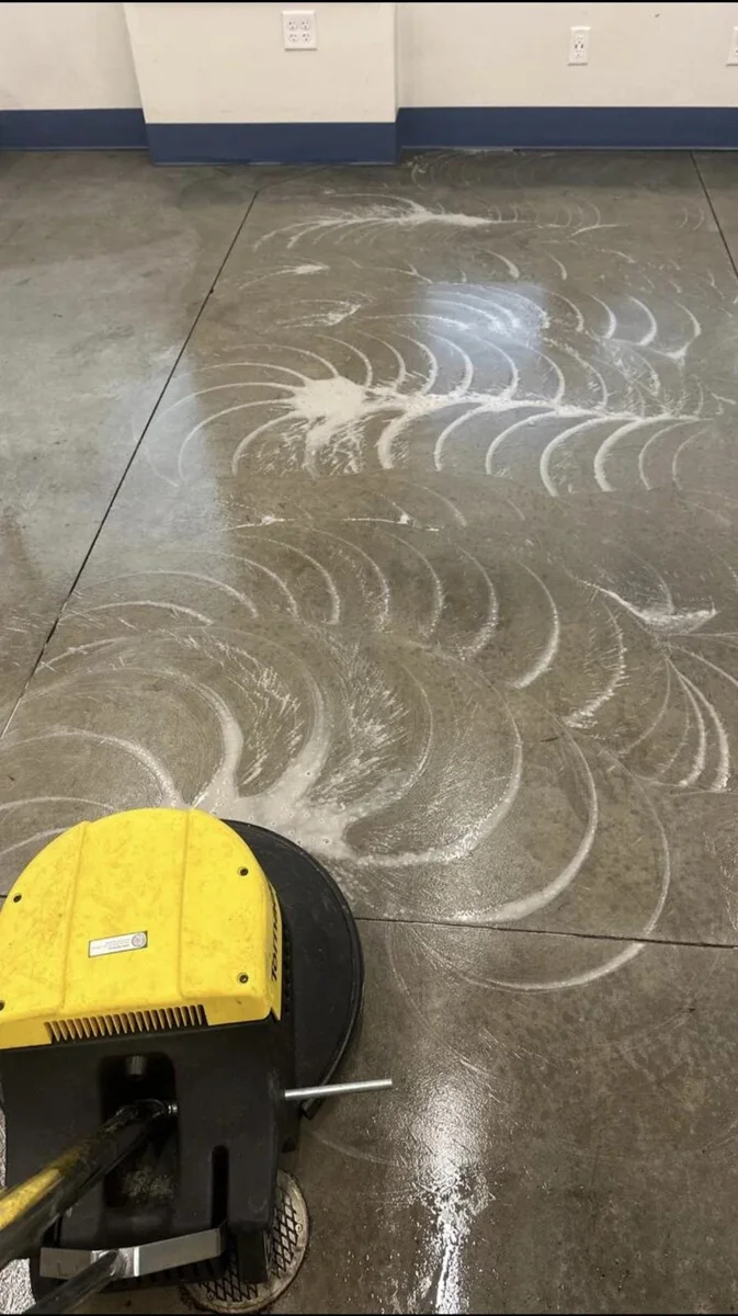 Floor-care equipment in use on a concrete floor